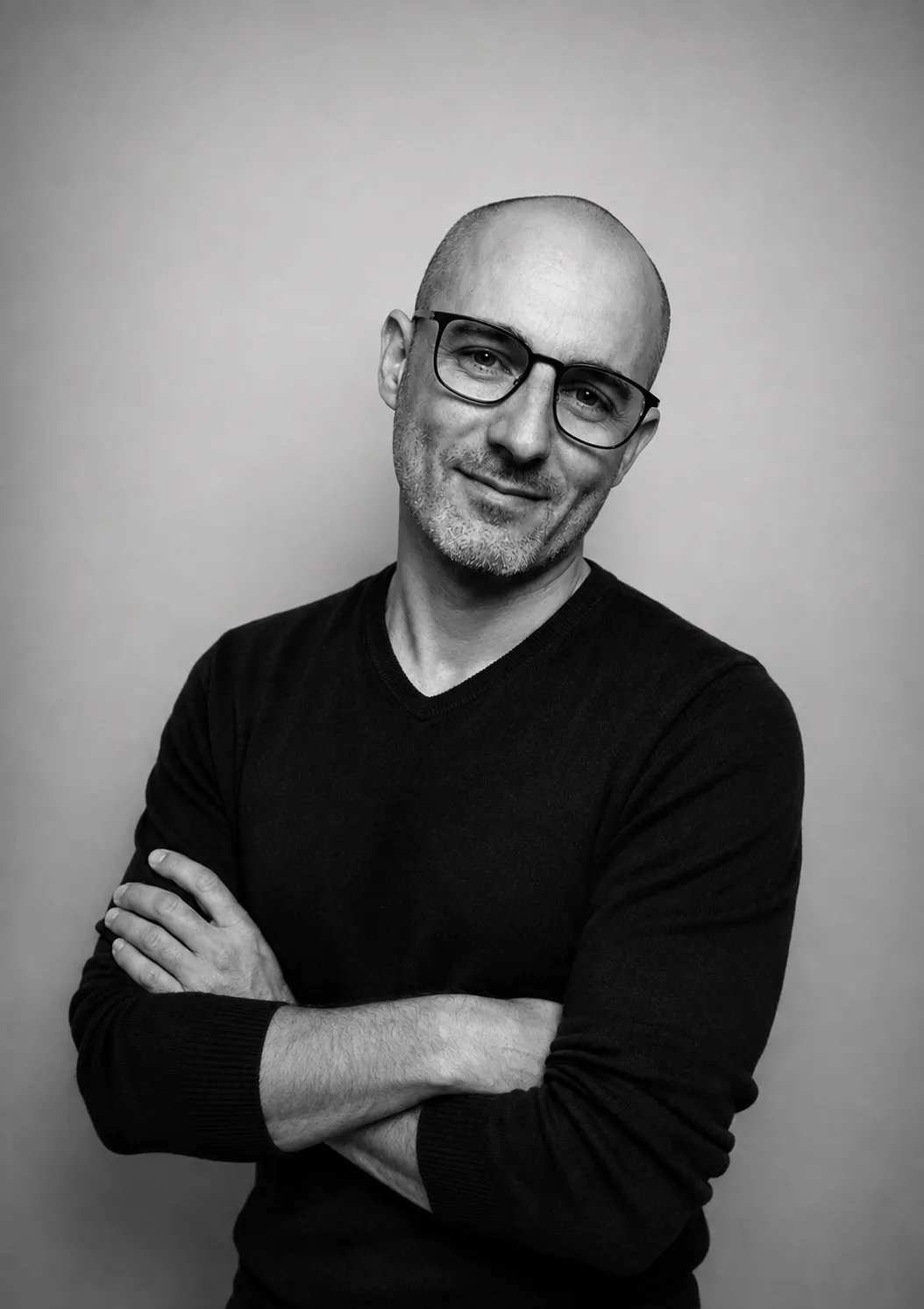 Portrait en noir et blanc d'Arnaud Le Camus, souriant, les bras croisés.